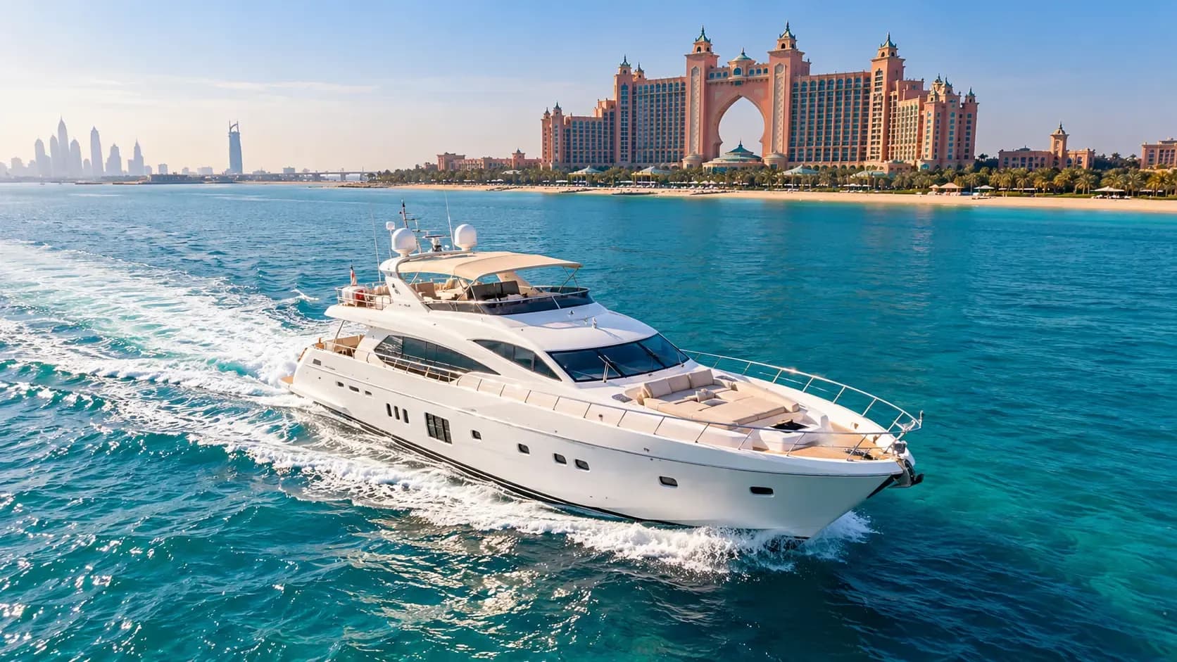 A white yacht cruising past Atlantis on Palm Jumeirah
